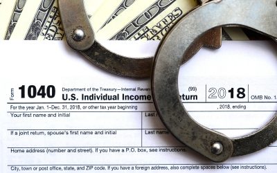 Police handcuffs lie on the tax form 1040